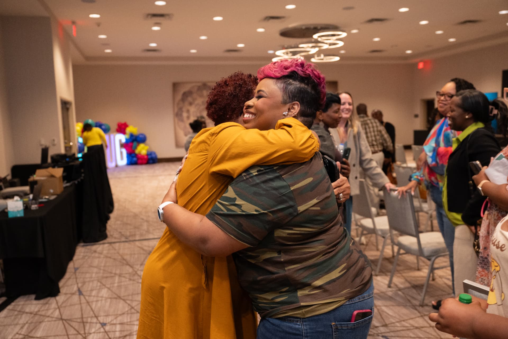 LaShawn hugging an attendee in the ballroom