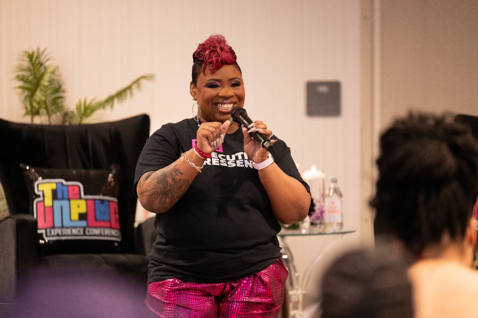 LaShawn smiling on stage with a microphone